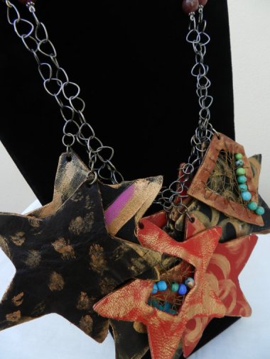 Materials: kindergarten artwork, cat hair, paper clips. Statement: My house is filled with tiny plastic dinosaurs