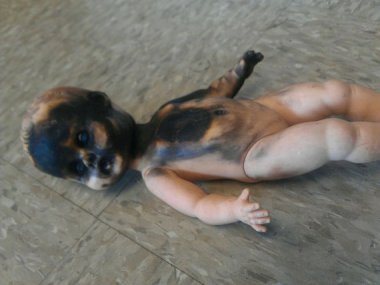 You really have to wonder what kind of wackadoodle saves this stuff. Burned doll sold by TheJinns, who makes a point of saying the doll is not haunted. Because that's not at all suspicious.